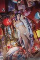 A woman in a bikini standing in front of a wall of paper lanterns.