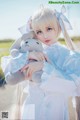 A woman in a white dress holding a stuffed animal.