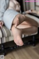 A woman sitting on a chair with her feet up.