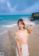 A woman standing on a beach next to the ocean.